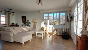 a living room with a white couch and windows at T3 indépendant Villa Heas in Argelès-Gazost