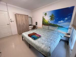 a bedroom with a bed with a painting on the wall at Lee Red House Homestay in Ban Ao Yai