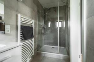a bathroom with a shower and a glass shower backdoor at NürbLife Hotel in Nürburg +52 photos