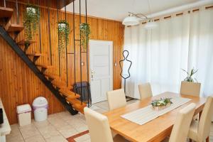 a dining room with a table and chairs and a staircase at Tompos Vendégház és pince in Villány +43 photos