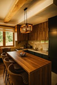 una cucina con tavolo in legno e frigorifero nero di Orahovo stone vilas a Virpazar