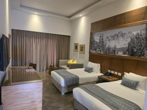 a hotel room with two beds and a couch at Cancun Sokhna Resort & Villas in Ain Sokhna