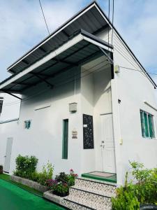 a white house with a door and stairs at เจเจรีสอร์ท in Ban Mo
