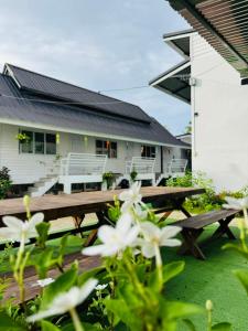 a picnic table in front of a house with flowers at เจเจรีสอร์ท in Ban Mo
