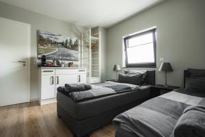 a bedroom with two beds and a couch in it at NürbLife Hotel in Nürburg