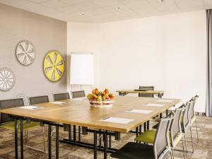 een conferentieruimte met een grote houten tafel en stoelen bij Hotel Ibis Łódź Centrum in Łódź