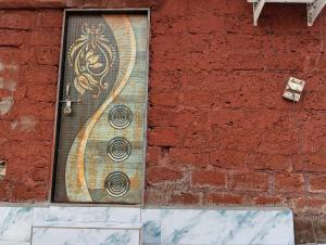 a door on a brick wall with a painting on it at Golden Oriole Homestay in Srīvardhan