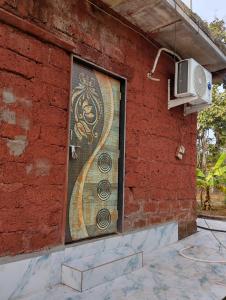 a mosaic on the side of a building with a tv at Golden Oriole Homestay in Srīvardhan