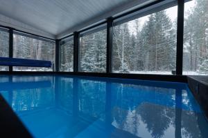 a swimming pool with a view of the snow covered trees at Keibulahe Puhkemaja in Keibu