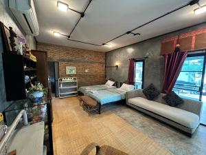 a living room with a bed and a couch at Ban Buarawong บ้านบัวระวงค์ in Ban Nong Faek