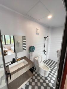 a bathroom with a white toilet and a sink at Bách Xanh House in Tam Ðảo