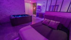 a purple room with a bed and a couch at MagicSpa91 in Chilly-Mazarin +6 photos