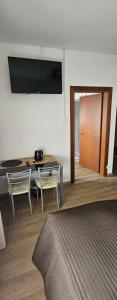 a room with a desk and a table and a door at l'igloo b&b in Sedico