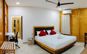 a bedroom with a large bed with red pillows at Greenwood Resort in Dhamni +7 photos