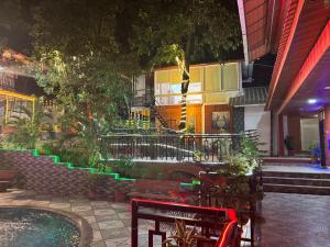 a bench in front of a building at night at Greenwood Resort in Dhamni
