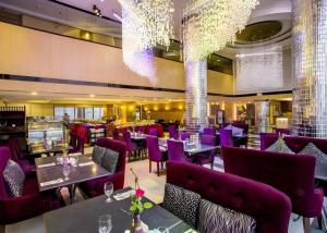 un ristorante con mobili viola e un lampadario di Le Monet Hotel a Camp John Hay