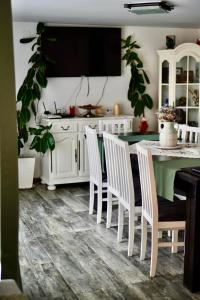 a kitchen with a table and white cabinets and plants at Agropa Rooms & Garden Events in Bistriţa