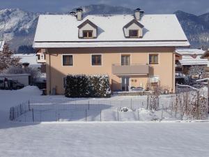 a house with snow on the ground in front of it at Ferienwohnung Fill in Bad Häring