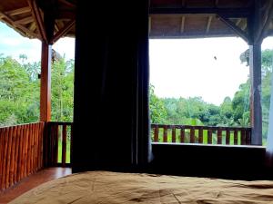 a bedroom with a bed and a large window at Bareng Homestay Tetebatu in Tetebatu