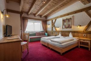 Hotel Gran Ciasa في كولفوسكو: غرفة فندقية بسريرين واريكة