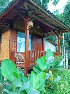 een huis met een houten terras met een stoel bij Bareng Homestay Tetebatu in Tetebatu