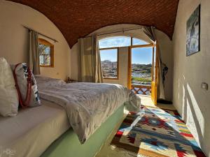 a bedroom with a bed and a large window at ASSINGAR Island in Aswan