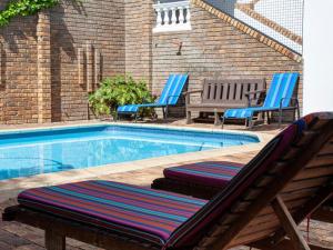 a swimming pool with two lounge chairs next to it at 5 Rembrandt Guesthouse in Somerset West