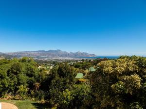 a view of the ocean from a hill with trees at 5 Rembrandt Guesthouse in Somerset West