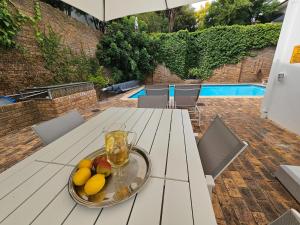 a plate of fruit on a table on a patio at 5 Rembrandt Guesthouse in Somerset West