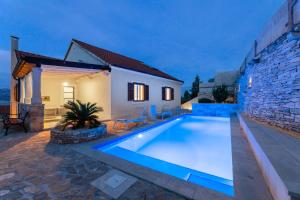 a swimming pool in the backyard of a house at Villa Aries in Supetar