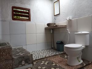a bathroom with a toilet and a tiled floor at Bareng Homestay Tetebatu in Tetebatu +35 photos
