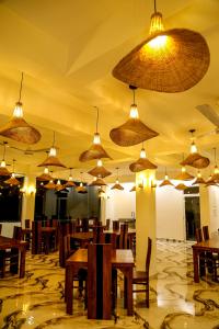 een restaurant met tafels en stoelen en veel lampen bij Ceylon Charm Mirissa in Mirissa
