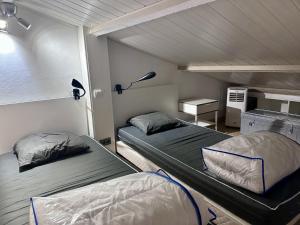 a room with two beds and a desk with a lamp at Appartement région de St-Tropez in Grimaud