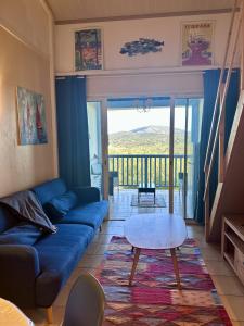 a living room with a blue couch and a table at Appartement région de St-Tropez in Grimaud