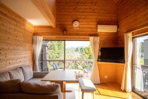 a living room with a couch and a table at 日田天ヶ瀬の源泉掛け流し温泉付き貸別荘 5名様まで同料金 in Hita