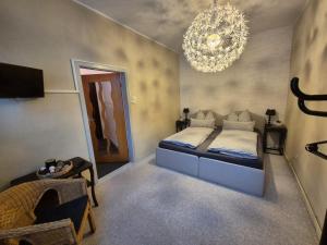 een slaapkamer met een bed en een kroonluchter bij Brummers Ferienwohnung in Wildemann