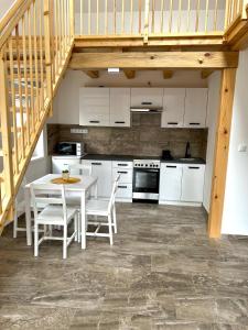 a kitchen with white cabinets and a table and chairs at Jolcsi Apartman in Balatonfüred