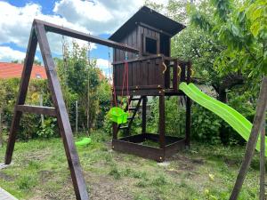 a tree house with a slide in a yard at Jolcsi Apartman in Balatonfüred