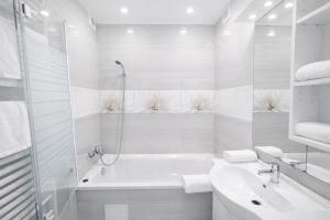 a white bathroom with a tub and a sink at Comfort 66 Large Family City Home in Miskolc +9 photos