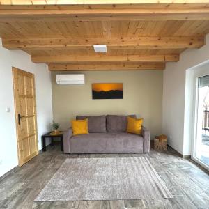 a couch in a living room with a wooden ceiling at Jolcsi Apartman in Balatonfüred +1 photo