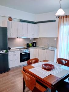 a kitchen with a wooden table and a table and chairs at Cozy apartment in Ialyssos in Ialyssos