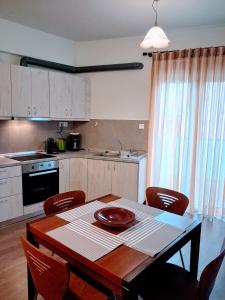 a kitchen with a wooden table with chairs and a table and a table at Cozy apartment in Ialyssos in Ialyssos