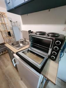 a kitchen with a stove and a sink at Le Nid, petit studio cosy et central in Besançon