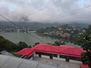 a view of a river and a building with a red roof at Pi Palace in Bhīm Tāl +4 photos