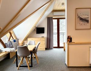 a room with a table and chairs in a attic at Villa Kaplowa Chata & SPA in Zakopane
