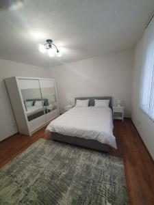 een witte slaapkamer met een bed en een spiegel bij Levkov in Petrich