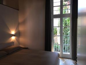 Un dormitorio con una cama y una ventana grande. en Porta 22 Charme&Relax, en Bérgamo