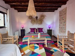 a bedroom with a large bed with a colorful rug at Riad Eucalyptus, hôtel de charme Essaouira in Essaouira +100 photos