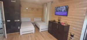 a room with a tv and white chairs and a table at Gastehaus in Kostyantynivka