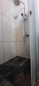 a bathroom with a shower with white tiled walls at Gastehaus in Kostyantynivka +17 photos
